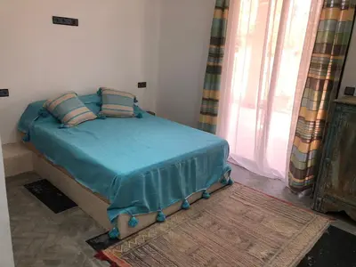 a bedroom with a bed with blue sheets and a window at Dar AZZARO in El Rhechat
