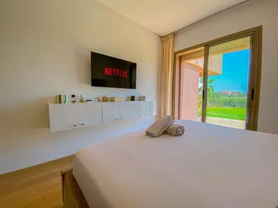 a bedroom with a large white bed and a window at Luxury Apartment in Prestigia Marrakech in Marrakech