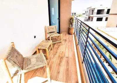 two chairs sitting on the balcony of a building at Large Private Pool, Breakfast Included, Near Golf in El Rhechat
