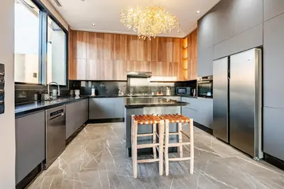 a kitchen with stainless steel appliances and a stool at Large Private Pool, Breakfast Included, Near Golf in El Rhechat