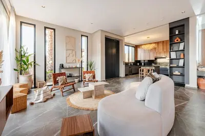 a living room with a white couch and a kitchen at Large Private Pool, Breakfast Included, Near Golf in El Rhechat