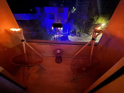 two chairs sitting on a balcony at night at Cozy Family Apartment 2BR Pool Parking Gueliz Marrakesh in Marrakech