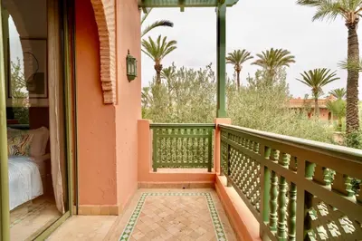 a balcony of a house with palm trees at Palmeraie vintage apartment with pool in Marrakech