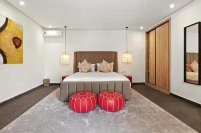 a bedroom with a bed with two red ottomans at Dariana guesthouse in Marrakech