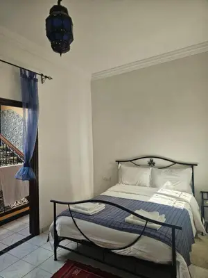 a bedroom with a bed and a chandelier at Riad zahra in Marrakech