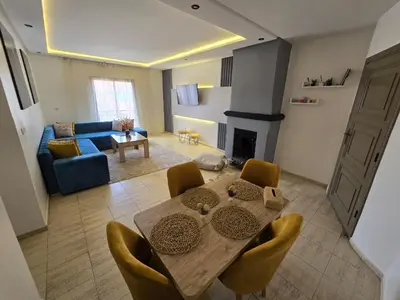 a living room with a table and chairs and a couch at Appartement Moderne Gueliz in Marrakech