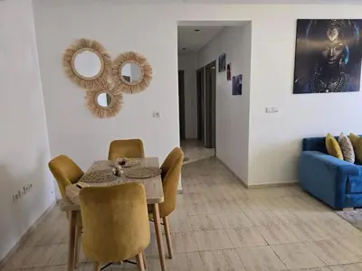 a dining room with a table and a blue couch at Appartement Moderne Gueliz in Marrakech