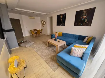 a living room with a blue couch and a table at Appartement Moderne Gueliz in Marrakech