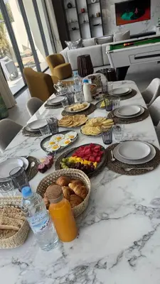 a table with plates and baskets of food and drinks at Villa Talya in Marrakech