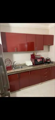 a kitchen with red cabinets and a sink at Atlas feeling in Marrakech