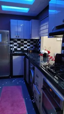 a kitchen with blue cabinets and a stove top oven at Bssatin gueliz in Marrakech