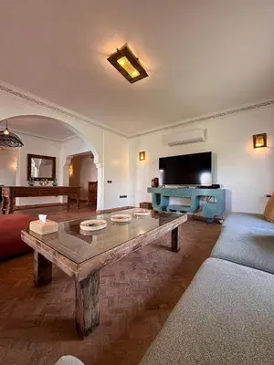 a living room with a coffee table and a tv at Villa Cactus & chill - Breakfast included! in Marrakech