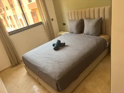 a bed with a toy on it with a window at Beautiful 5 bedroom duplex! Pool! in Oulad Akkou