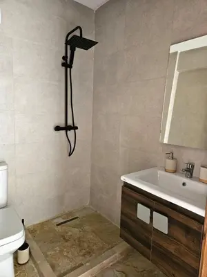 a bathroom with a shower and a sink and a toilet at Beautiful 5 bedroom duplex! Pool! in Oulad Akkou
