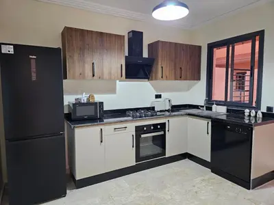a kitchen with black appliances and a black refrigerator at Beautiful 5 bedroom duplex! Pool! in Oulad Akkou