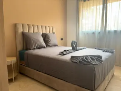 a bedroom with a large bed with towels on it at Beautiful 5 bedroom duplex! Pool! in Oulad Akkou