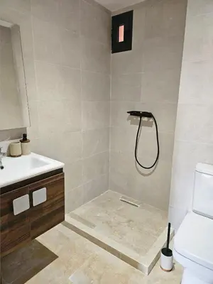 a bathroom with a shower and a sink and a toilet at Beautiful 5 bedroom duplex! Pool! in Oulad Akkou