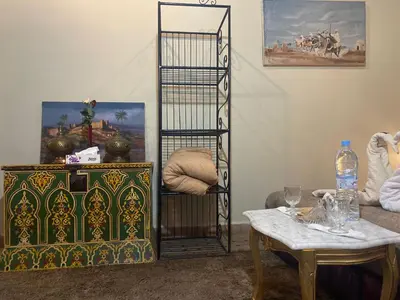 a living room with a table and a chair and a shelf at Riad Massin Marrakech in Marrakech