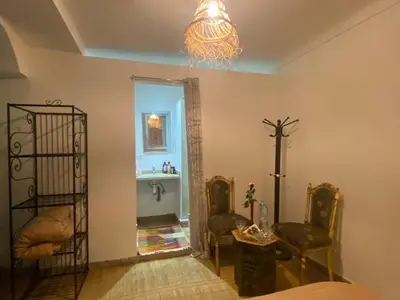 a room with two chairs and a cross on the wall at Riad Massin Marrakech in Marrakech