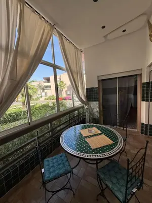 a table and chairs in a room with a large window at Riad Garden Apartement & WiFi & Pool & Parking in Marrakech