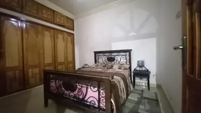 a bedroom with a bed in a room with wooden doors at Appartement 2 Chambres à Belbekkar, Marrakech in Marrakech