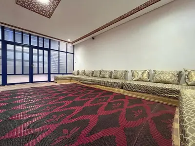 a large room with a couch and a carpet at Maison d'hôtes Marrakech in Marrakech
