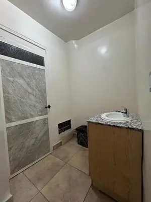 a bathroom with a sink and a glass shower door at Maison d'hôtes Marrakech in Marrakech