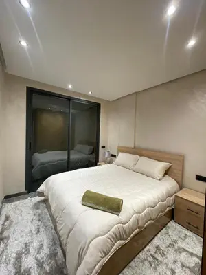 a bedroom with a large bed with a green pillow on it at Apartment for rent in Marrakech