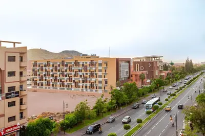 a city street with a building and cars on the road at Guéliz Marrakech-Authentique, spacieux , central in Marrakech