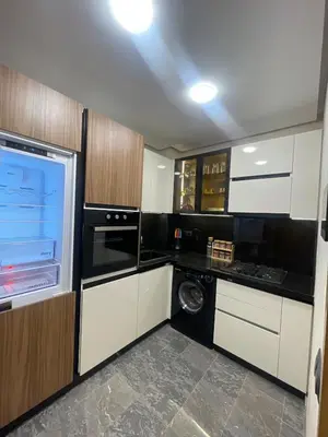 a kitchen with white cabinets and a washer and dryer at Apartment for rent in Marrakech