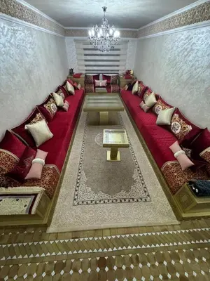 a living room with a red couch and a chandelier at شقة بغرفة معيشة مغربية in Marrakech