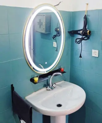 a bathroom with a sink with a round mirror at Appartement Marrakech à 10 minutes de l'aéroport in Marrakech