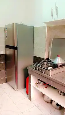 a kitchen with a stove and a stainless steel refrigerator at Kawtar in Marrakech