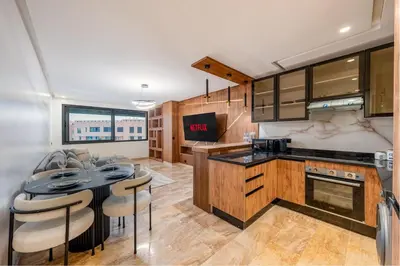 a kitchen with a table and some chairs in it at 1 Ch, 1 SDB et Parking gratuit au Centre de Gueliz avec vue in Marrakech