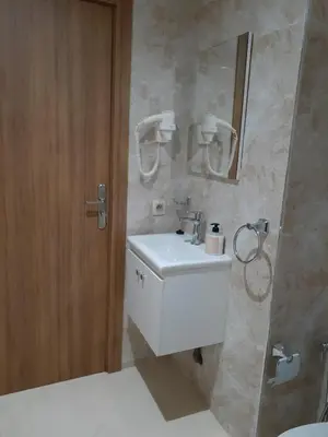 a bathroom with a white sink and a mirror at Appartement cosy à 8 min de RAK à pied in Marrakech