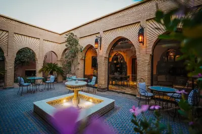 a courtyard with tables and chairs and a fountain at La Villa Wassim in Marrakech