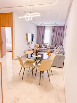 a living room with a table and chairs and a couch at Modern apartment in Gueliz Luxury residence in Marrakech