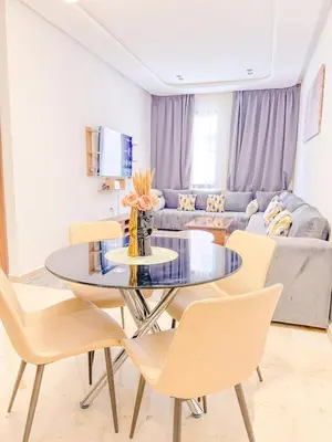 a living room with a glass table and chairs at Modern apartment in Gueliz Luxury residence in Marrakech