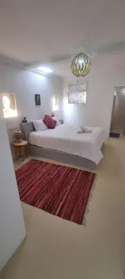a bedroom with a large bed and a rug at VILLA Malaika in Marrakech