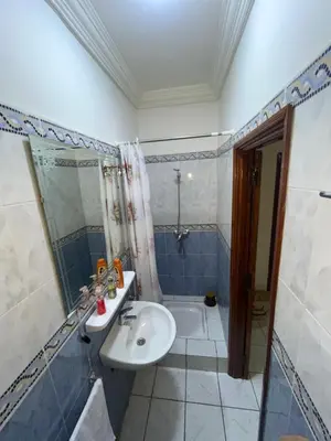 a blue and white bathroom with a sink and a shower at Riad Mounaf in Marrakech