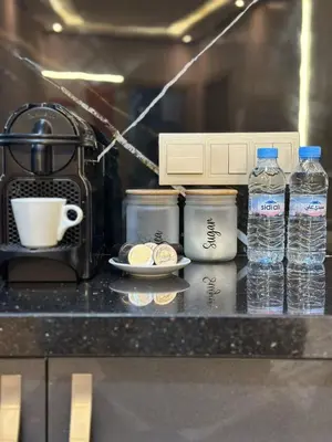a counter with a coffee maker and two bottles of water at Homekesh in Marrakech