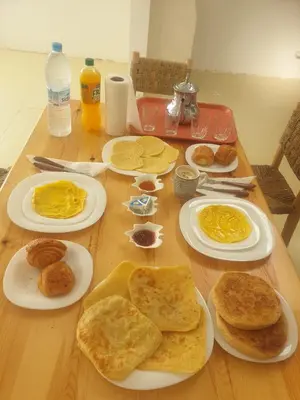 a wooden table topped with plates of breakfast food at Villa NAIM in Marrakech