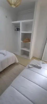 a white room with two beds and a shelf at Villa NAIM in Marrakech