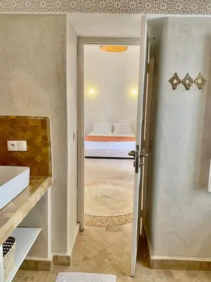 a bathroom with a door leading to a bedroom at Riad Nouonsa 4ch 8 pax Medina Bab Taghzout in Marrakech