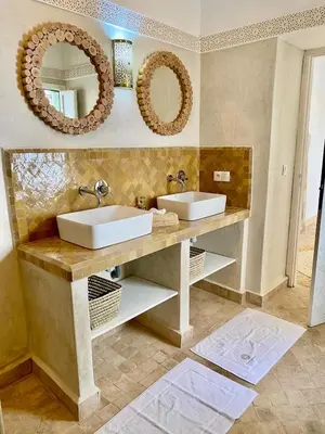 a bathroom with two sinks and two mirrors at Riad Nouonsa 4ch 8 pax Medina Bab Taghzout in Marrakech