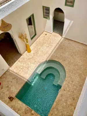 a pool of turquoise water in a tile floor at Riad Nouonsa 4ch 8 pax Medina Bab Taghzout in Marrakech