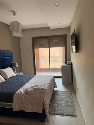 a bedroom with a bed and a television and a window at Near Gueliz 2 Bedrooms 3 ACs Fast WiFi Netflix in Marrakech