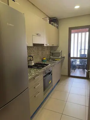 a kitchen with a refrigerator and a stove top oven at Near Gueliz 2 Bedrooms 3 ACs Fast WiFi Netflix in Marrakech