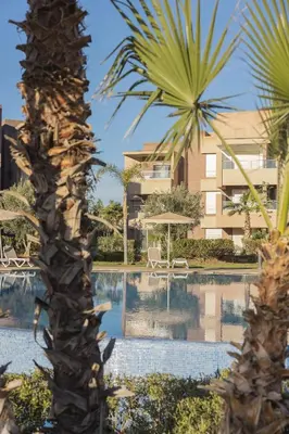 a resort with a palm tree and a swimming pool at Beautiful 3 bedroom apartment for 6 people Prestigia Golf Saphir in Marrakech