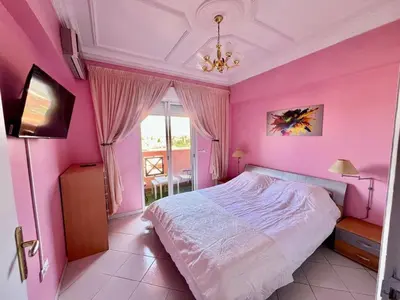 a pink bedroom with a bed and a window at NF15 by Majestic Properties in Marrakech